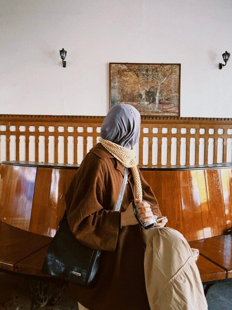 A woman in a hijab sitting on a bench